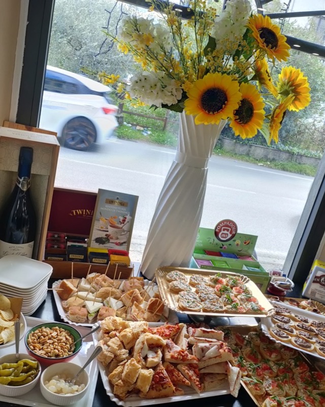 Tavolo del buffet allestito accanto alla vetrata con girasoli